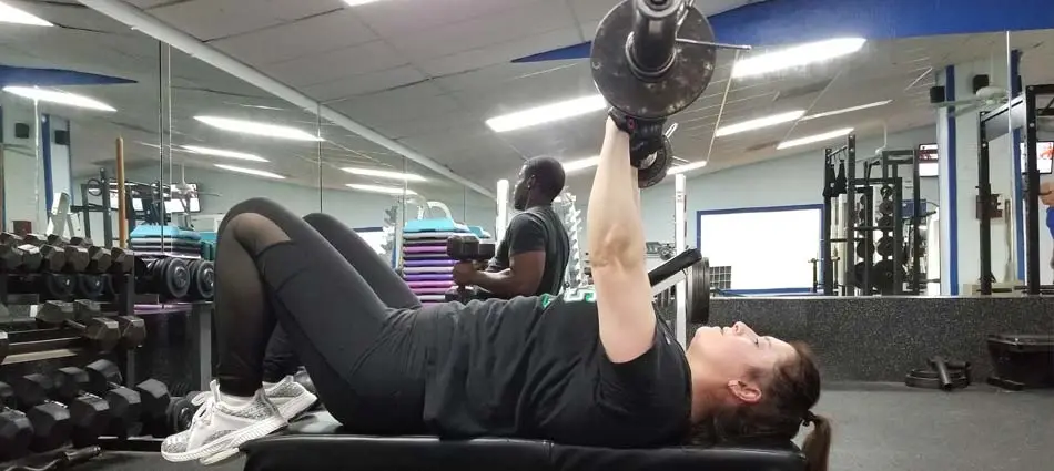 Personal training client doing skull crushers at the gym in Apollo Beach, FL.